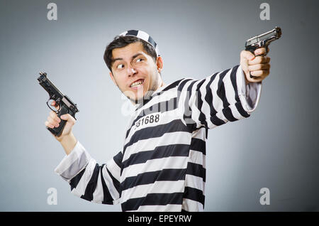 Prigioniero con la pistola contro uno sfondo scuro Foto Stock