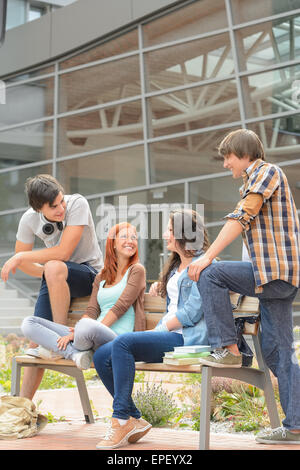 Gli studenti amici seduti davanti al banco di università Foto Stock