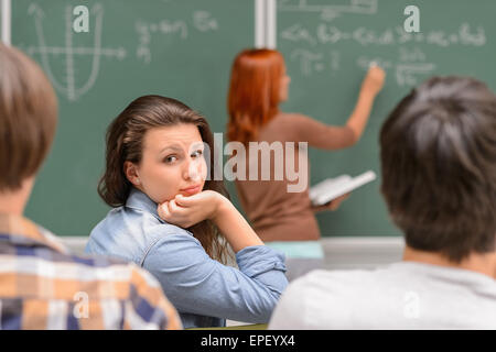 Annoiato studente ragazza durante le lezioni di matematica Foto Stock