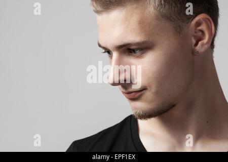 Considerato giovane uomo caucasico isolato su grigio Foto Stock