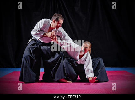 Lotta a due fra aikido fighters su nero Foto Stock