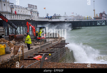 Brighton, Regno Unito. 18 Maggio, 2015. Operai battaglia contro il brutto tempo come onde infrangersi sul mare groyne difesa sono la riparazione presso il molo sul lungomare di Brighton questa mattina Credito: Simon Dack/Alamy Live News Foto Stock