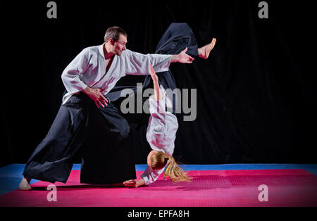 Lotta a due fra aikido fighters su nero Foto Stock