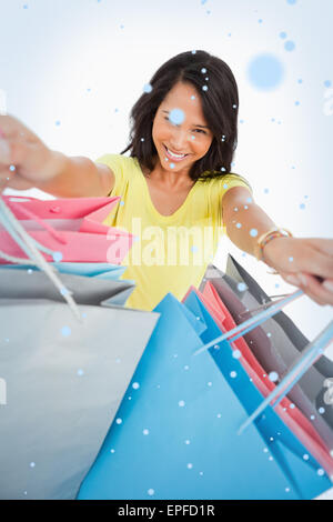 Immagine composita di highangle vista di una giovane donna che mostra delle borse per lo shopping Foto Stock