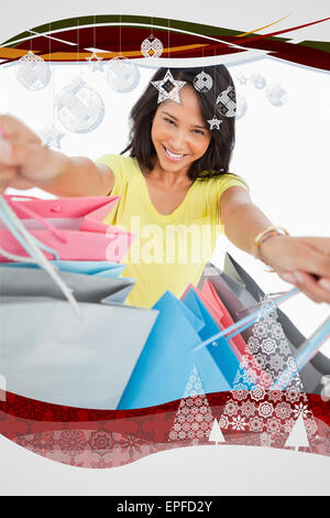 Immagine composita di highangle vista di una giovane donna che mostra delle borse per lo shopping Foto Stock