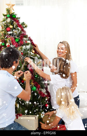 Immagine composita di gioiosa famiglia decorare albero di natale Foto Stock