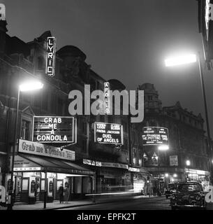 Vista guardando verso il basso Shaftsbury Avenue nel West End di Londra che mostra la lirica, Apollo e teatri del globo. Aprile 1958. Foto Stock