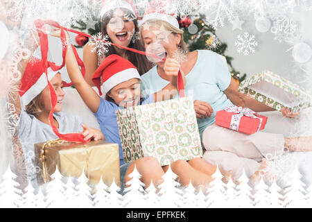 Immagine composita della famiglia felice a Natale regali di apertura insieme Foto Stock