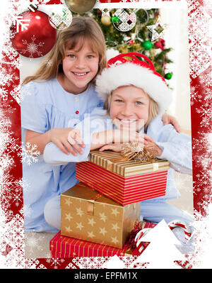 Immagine composita di sorridere i fratelli azienda regali di natale Foto Stock