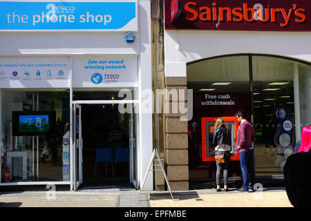 Un Tesco Phone Shop accanto a un locale supermercato Sainsbury's nel centro di Bristol. Foto Stock