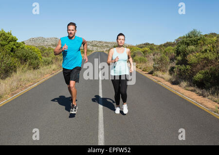 Montare il giovane jogging sulla strada aperta insieme Foto Stock