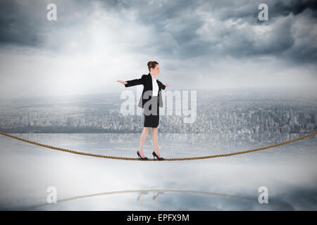 Immagine composita di imprenditrice di eseguire un esercizio di equilibrismo sulla fune Foto Stock