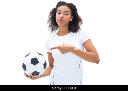 Piuttosto appassionato di calcio in bianco tenendo palla e rivolta verso di essa Foto Stock