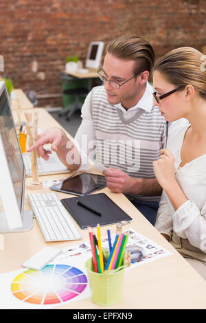 Concentrato casual editor di foto tramite il computer in ufficio Foto Stock
