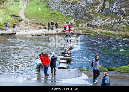 I turisti a piedi oltre le pietre miliari a Dovedale sul Staffordshire e Derbyshire confine sul fiume Colomba England Regno Unito Foto Stock