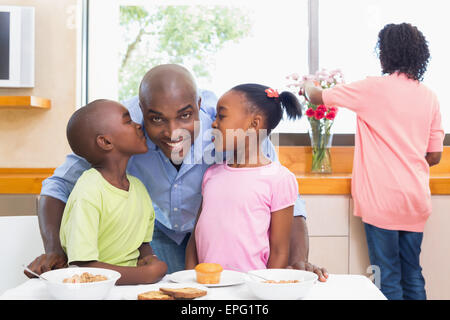 La famiglia felice avente insieme per la prima colazione al mattino Foto Stock