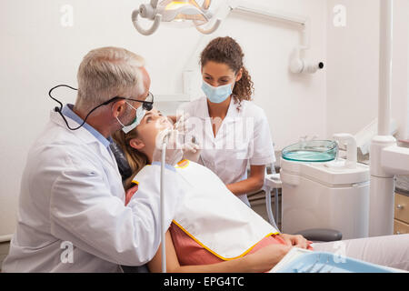 Dentista e assistente esaminare pazienti denti Foto Stock