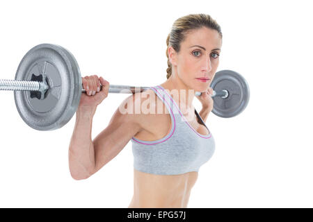 Femmina forte sollevamento crossfitter barbell dietro la testa guardando la fotocamera Foto Stock