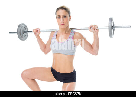 Femmina forte sollevamento crossfitter barbell dietro la testa guardando la fotocamera Foto Stock