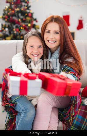 Festive madre e figlia avvolto in una coperta con doni Foto Stock