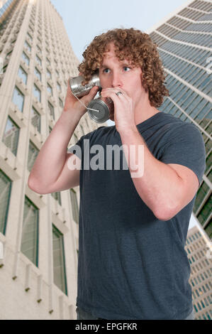 L'uomo usando stagno può telefono Foto Stock