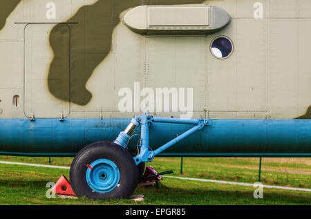 Un frammento del vecchio tipo di autocarro pesante elicottero militare di close-up. Carrello di atterraggio di un elicottero sul prato verde. Foto Stock