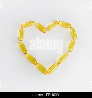 Capsule a forma di cuore ad olio di pesce. Vitamine per la promozione della salute. Concetto foto. Foto Stock