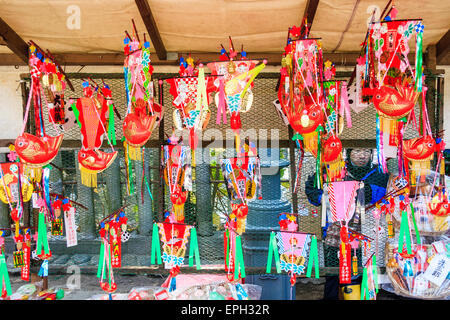 Il fascino della buona fortuna, la Kumade rossa, i rastrelli ornamentali di bambù decorati con una varietà di talismani, appesi ad un santuario di Shinto durante il festival del nuovo anno Foto Stock