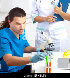 Il ricercatore prende il tubo di prova in un laboratorio Foto Stock