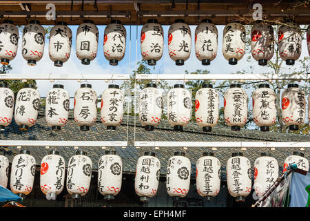 File di chochin, lanterne di carta, appese da una porta di vermiglio torii sull'ingresso si avvicina alla parte principale del santuario di Yasaka a Kyoto, Giappone. Foto Stock