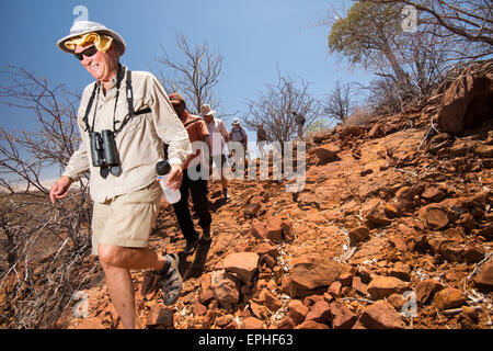 Africa, Namibia. Escursione di un giorno il monitoraggio del deserto rinoceronte nero. Gruppo di turisti escursionismo. Foto Stock