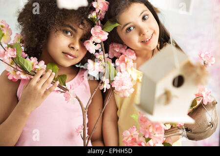 Due cute ragazze con splendidi fiori di colore rosa Foto Stock