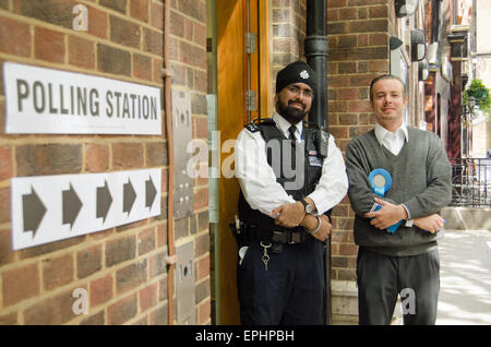 Londra, UK, 7 maggio 2015: un poliziotto e di un Bancomat dal partito conservatore al di fuori della stazione di polling in Westminster London Foto Stock