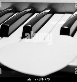 Cuore di carta sulla tastiera di pianoforte in bianco e nero e a colori bianco Foto Stock