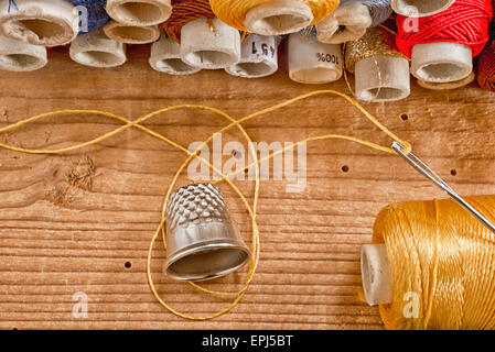 Un kit da cucito sulla vecchia scrivania in legno Foto Stock