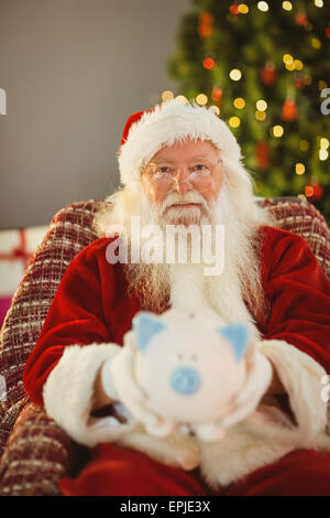 Babbo Natale offrendo salvadanaio Foto Stock