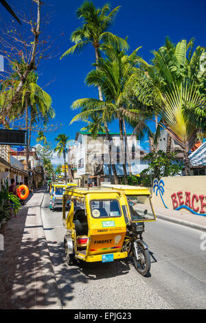 Il trike moto taxi traffico su Boracay Island strada principale nelle Filippine Foto Stock