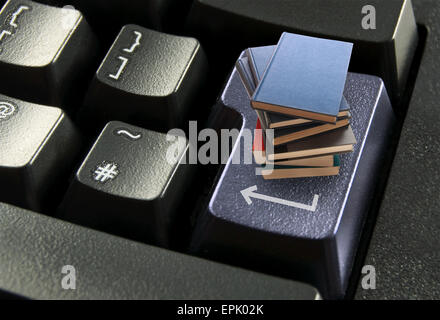 Libri online, impilato su un computer il tasto invio Foto Stock