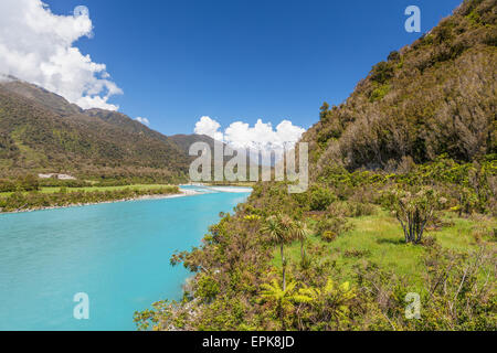 Vista del fiume Whataroa al Sud delle Alpi in distanza. West Coast, South Island, in Nuova Zelanda. Foto Stock