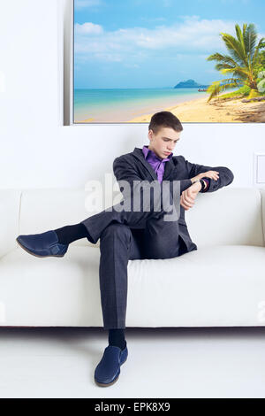 Imprenditore bello seduto sul divano nel suo ufficio Foto Stock