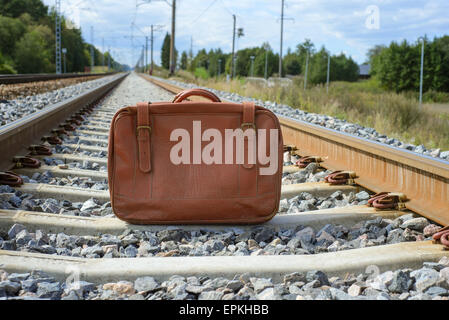 Vintage valigia marrone sulla ferrovia Foto Stock