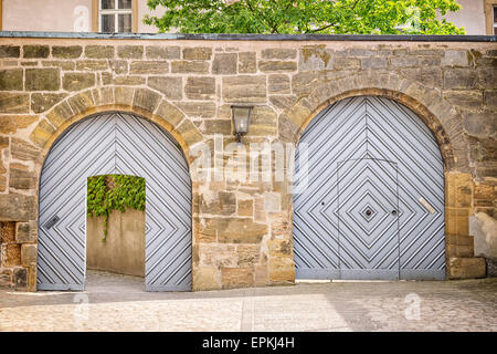 Immagine con due porte in una parete dove un cancello viene aperto, l'altra è chiusa. Foto Stock