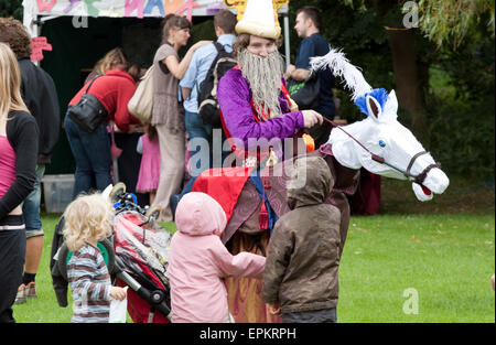 Un tradizionale polacco clown su una finta di cavallo in un parco di Southend Foto Stock