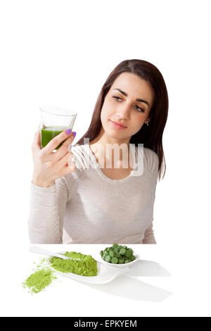 Bella ragazza sorridente holding succo verde in mano. Spirulina, clorella e wheatgrass. Uno stile di vita sano, detox. Foto Stock