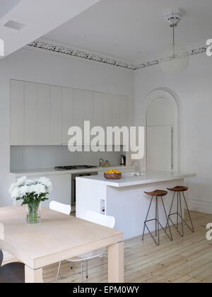 Un piccolo tavolo da pranzo, breakfast bar e sgabelli in cucina bianca, Chelsea Townhouse, New York, Stati Uniti d'America Foto Stock