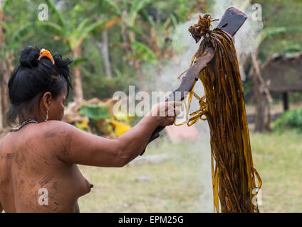 Panama, Provincia di Darien, Puerta Lara, Wounaan tribù donna Usinf uno speciale bastone di legno per tingere i vestiti Foto Stock