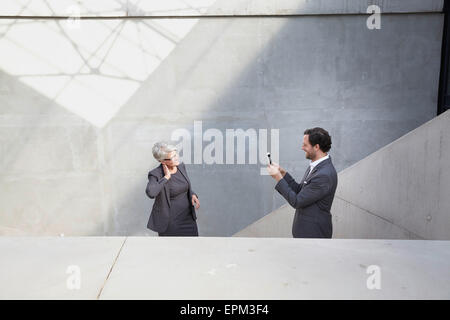 Imprenditore a fotografare il suo collega di sesso femminile con la fotocamera Foto Stock
