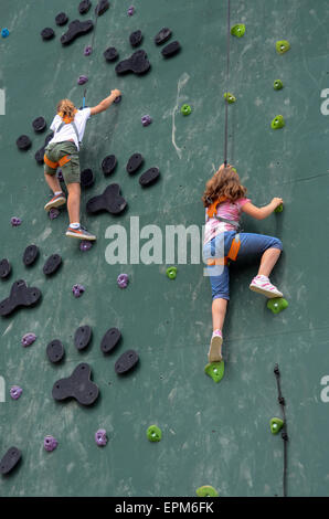 Le giovani ragazze avente un avventura Arrampicata e il passaggio a un parco di divertimento. Qui essi sono salite su una parete. Foto Stock