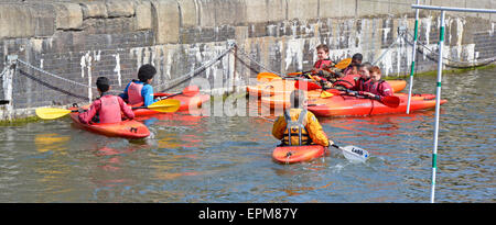 Gruppo di ragazzi e lezione di kayak in acqua al bacino di Shadwell da un istruttore adulto presso il Canoe Club Tower Hamlets East London England UK Foto Stock