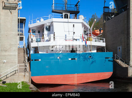 Grande nave da carico arriva alla stretta di gateway Tsvetochnoye lock sul Saimaa Canal, un canale di trasporto che collega il lago di S Foto Stock